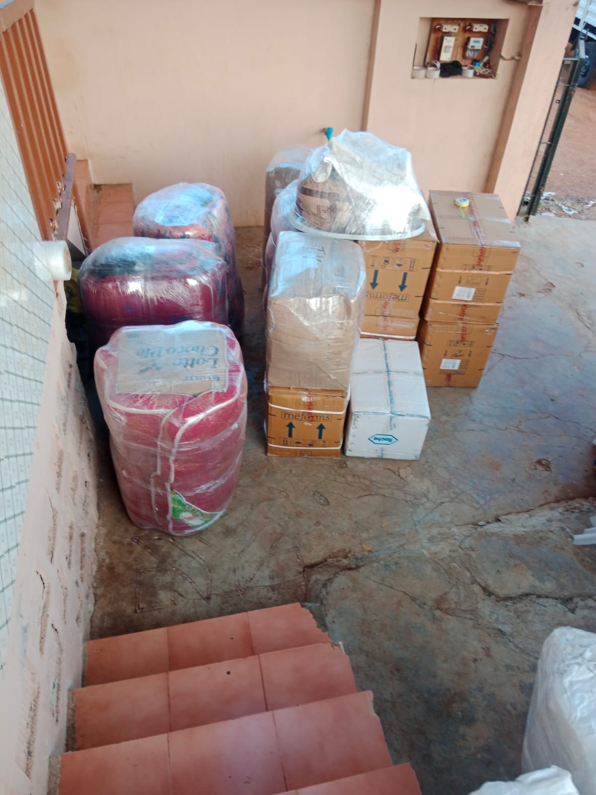 Packed boxes and wrapped household items arranged near stairs for local shifting